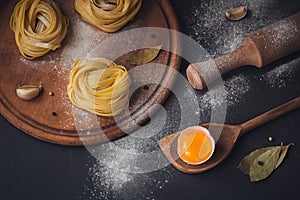 Raw homemade pasta with flour and spices on the rustic background.