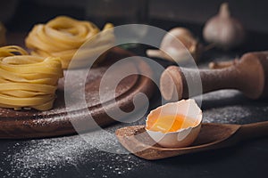 Raw homemade pasta with flour and spices on the rustic background.