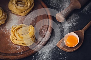 Raw homemade pasta with flour and spices on the rustic background.