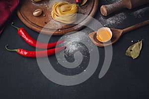 Raw homemade pasta with flour and spices on the rustic background.