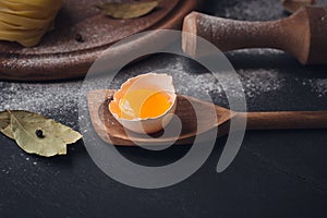 Raw homemade pasta with flour and spices on the rustic background.