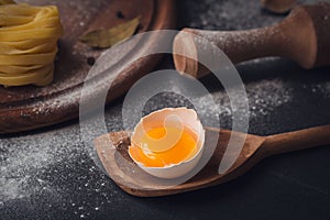 Raw homemade pasta with flour and spices on the rustic background.