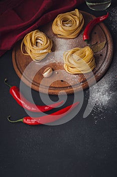 Raw homemade pasta with flour and spices on the rustic background.