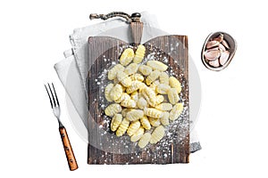 Raw homemade potato gnocchi with fork on wooden cutting board. Isolated, white background.