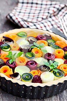 Raw homemade vegetarian pie with colored vegetables. Ready for