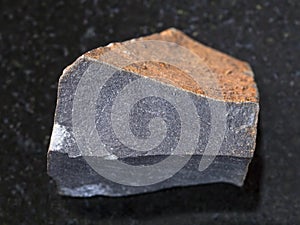 raw hyalobasalt (tachylite) stone on dark