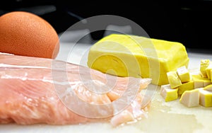 Raw ingredient of Egg, Tofu and Chicken Breast on a Cutting Board