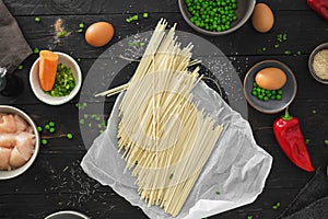 Raw ingredients cooking udon noodles chicken meat dark wooden table top view