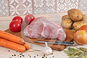Raw ingredients on table in kitchen, cooking stewed potatoes with meat. Soup with meat, potatoes, carrots, parsley, garlic, pork,