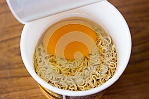 raw instant noodle in cup add egg