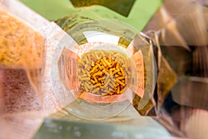 Raw italian macaroni pasta inside clear packaging