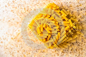 Raw italian macaroni pasta inside clear storage container