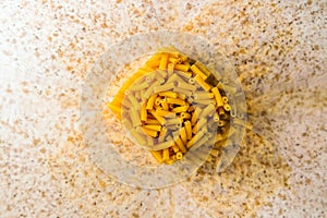 Raw italian macaroni pasta inside clear storage container