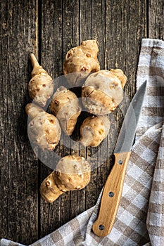 Raw jerusalem artichoke. Topinambur vegetable root on wooden table