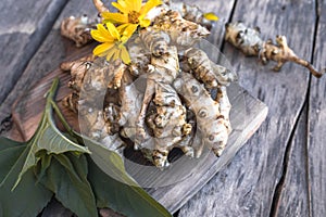 Raw jerusalem artichoke. Topinambur vegetable root on wooden table