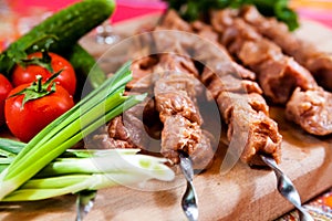 Raw kebab with onion on wooden board