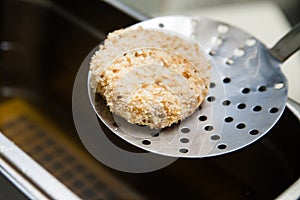 Raw Kiev chicken on perforated spoon