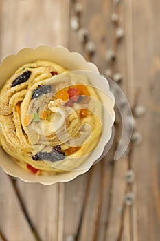 raw kraffin kulich with candied fruit on wooden table with sprigs of willow top view