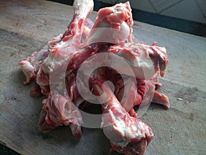 Raw lamb bones on a wooden chopping board