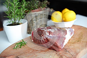 Raw lamb leg meat on the wooden cutting board