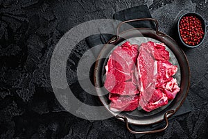 Raw Lamb leg steaks on butcher table. Black background. Top view. Copy space