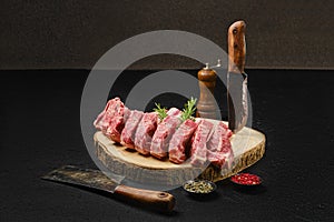 Raw lamb rib roast on wooden slab