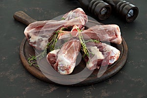 Raw lamb shank on dark background