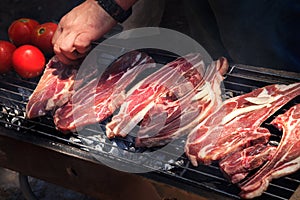 raw lamb steaks on a big grill barbecue