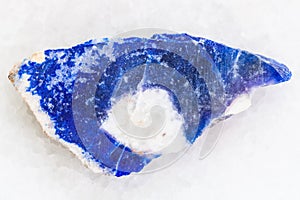 raw lazurite (lapis lazuli) stone on white marble
