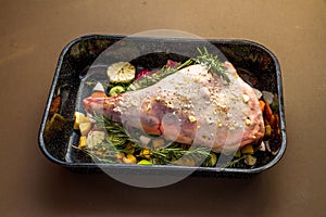 Raw Leg of lamb in roasting tray dressed with vegetables