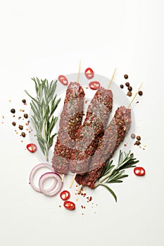 Raw lula kebab, herbs and spices on white background