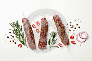 Raw lula kebab, herbs and spices on white background