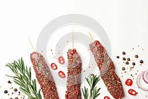 Raw lula kebab, herbs and spices on white background