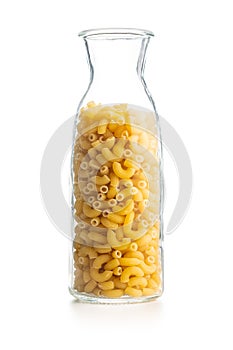 Raw macaroni pasta in glass bottle. Uncooked rigatoni isolated on white background