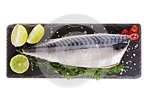 Raw mackerel with lemon and herbs on black slate cutboard