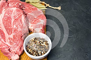 Raw marbled beef steak. Close-up photo on dark background