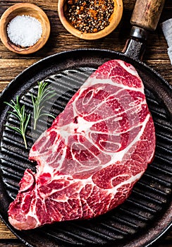 Raw marbled beef steak on grill pan photo