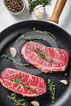 Raw marbled beef steak, top blade meat steak. Gray background. Top view