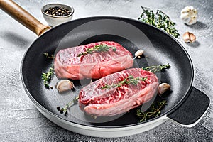 Raw marbled beef steak, top blade meat steak. Gray background. Top view