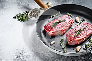 Raw marbled beef steak, top blade meat steak. Gray background. Top view. Copy space