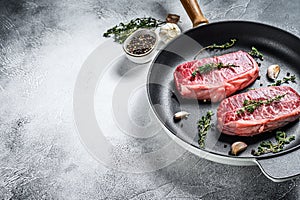 Raw marbled beef steak, top blade meat steak. Gray background. Top view. Copy space