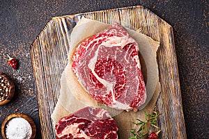 Raw marbled ribeye steak and spices