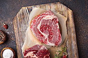 Raw marbled ribeye steak and spices photo