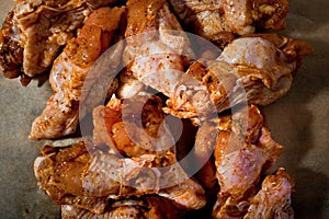 Raw marinated chicken wings on parchment - ready for cooking.