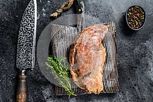 Raw marinated in mustard beef tri-tip steak for bbq. Black background. Top view