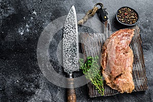 Raw marinated in mustard beef tri-tip steak for bbq. Black background. Top view. Copy space