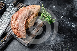 Raw marinated in mustard beef tri-tip steak for bbq. Black background. Top view. Copy space