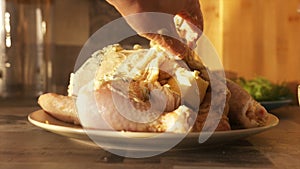 Raw marinated whole chicken for baking in the oven. Action. Close up of woman hand putting white cream sauce with