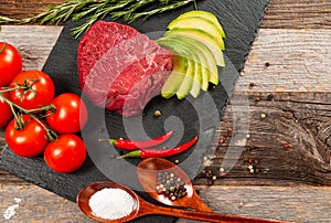 Raw meat, beef with spices for cooking on black board