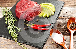 Raw meat, beef with spices for cooking on black board